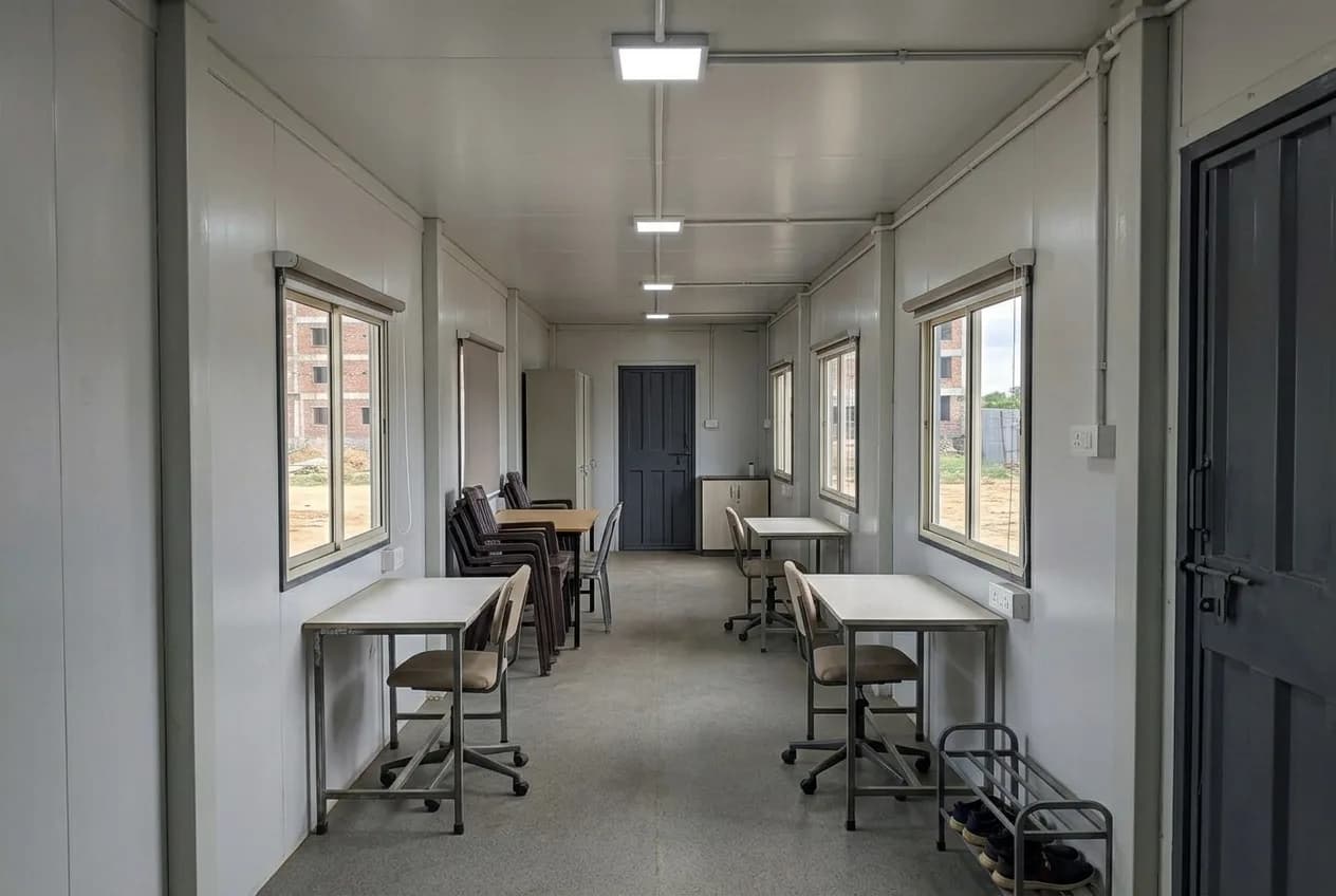 Interior of the 40 × 10 ft portable site office with tables, chairs and LED lighting