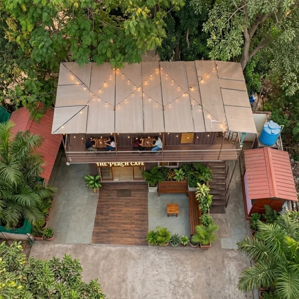Aerial view of the double-storey container cafe with string-lit rooftop seating and landscaped patio