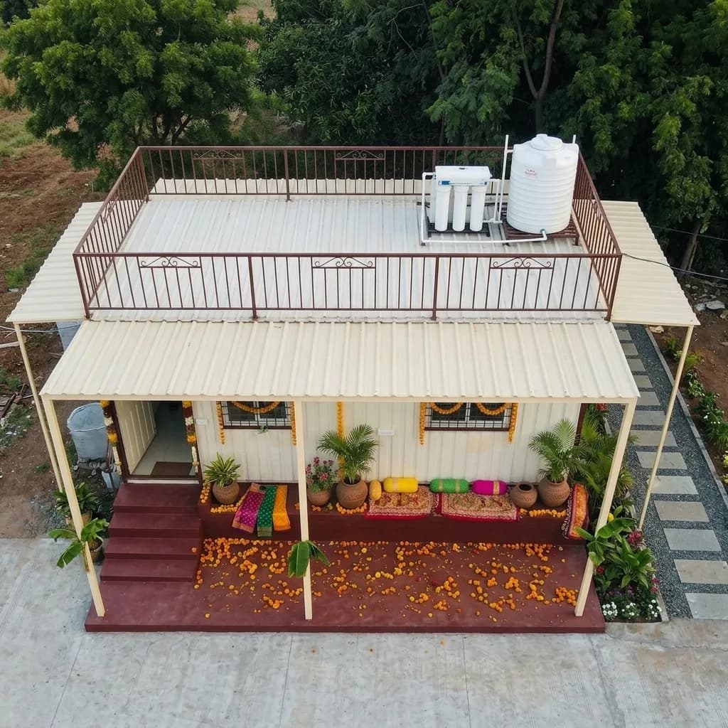 Aerial view of the portable farmhouse showing the rooftop terrace, overhead water tank and covered verandah