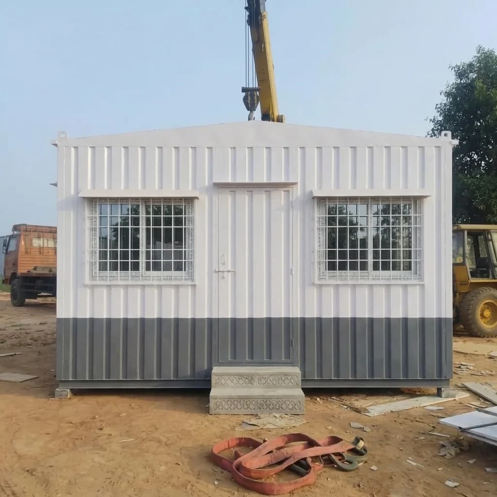White and grey portable office cabin available on rent, with a personnel door and two grilled windows, by Porta Cabin Systems