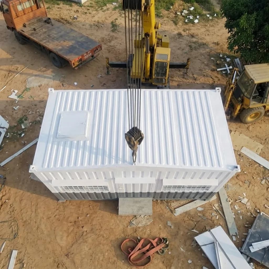 Top view of the portable office cabin being craned into place, showing the roof and vents
