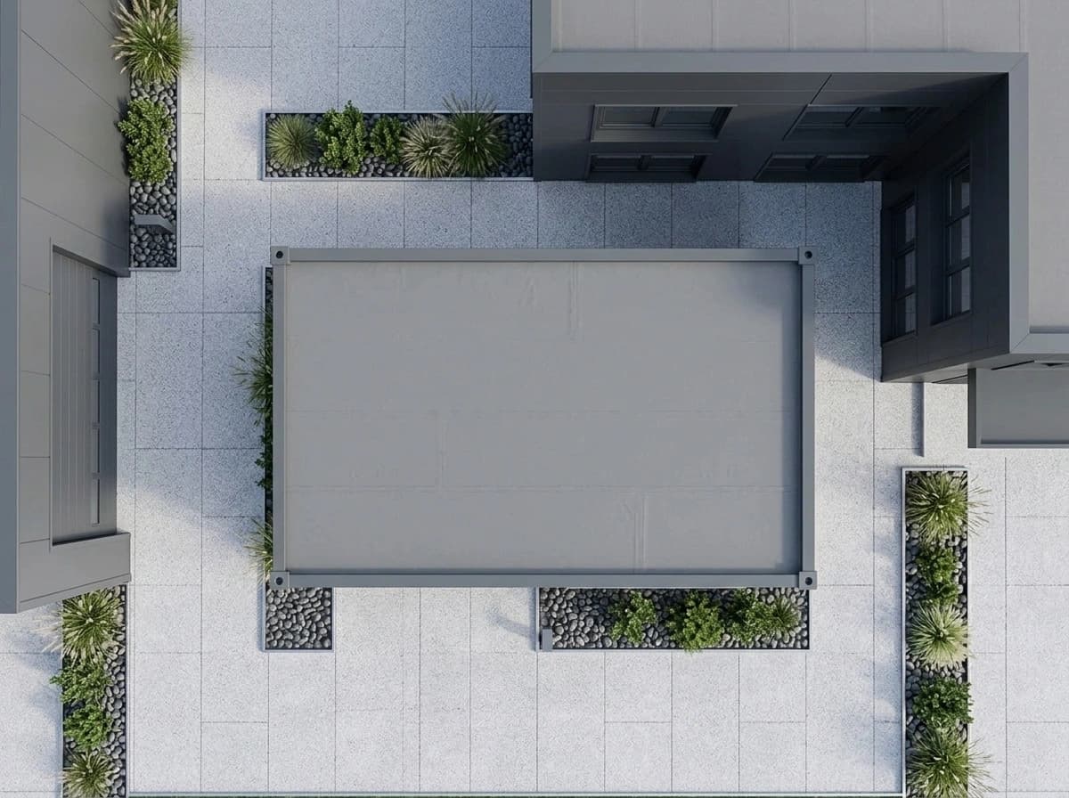 Design visualisation of the portable cabin seen from above, showing its flat grey roof inside a darker frame, on a paved pad among planted gravel beds beside a larger building
