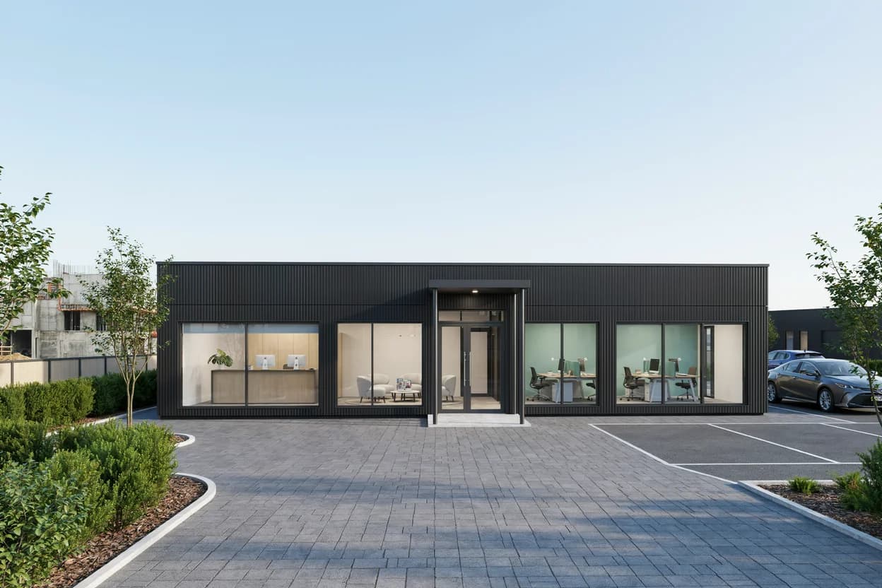 Design visualisation of a single-storey office clad in dark vertical ribbed sheeting, front-on, with a glazed double-door entrance under a small canopy between four large windows, behind a paved forecourt