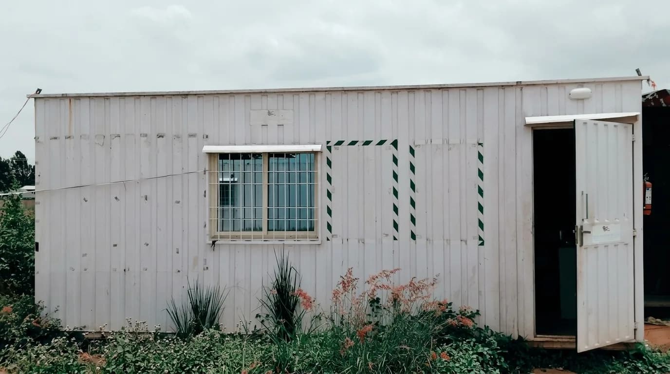 Actual Second-Hand Portable Office Cabin with Half Partition, 20 by 10 by 8.5 feet — front elevation with the entry door and a sliding window with safety grill